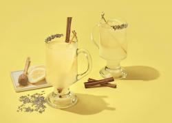 Yellow background with hot toddy's, lemons, honey, and cinnamon sticks