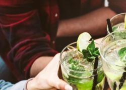 A group of friends cheersing with Fresh Cucumber Gin Mojitos