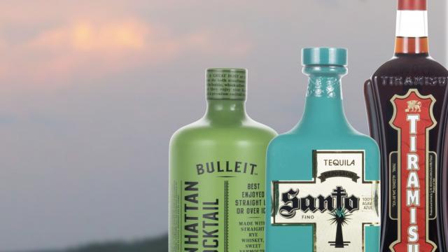 Three bottles of liquor on a sunset background