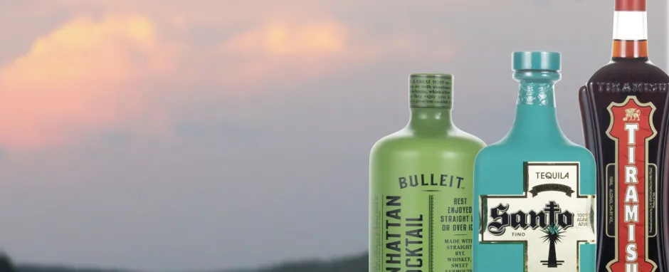 Three bottles of liquor on a sunset background