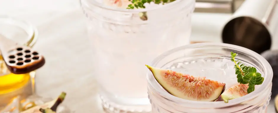 pink margaritas in glass with fig garnish