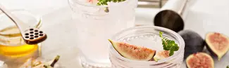 pink margaritas in glass with fig garnish